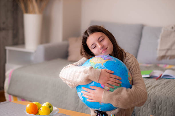 istock Teenage girl hugging a globe 2209714092