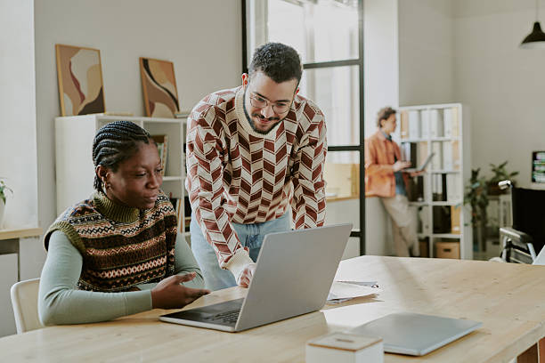 istock Male IT Office Worker Helping Colleague 2209715628