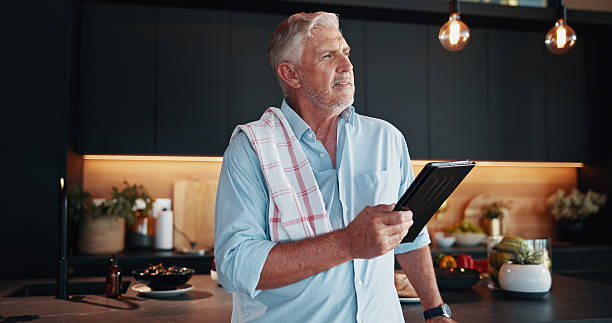 istock Mature man, tablet and meal prep idea with thinking, dinner tutorial or online guide in home. Learning, instructions and senior person in kitchen with decision, diet planning or blog recipe steps 2209716951