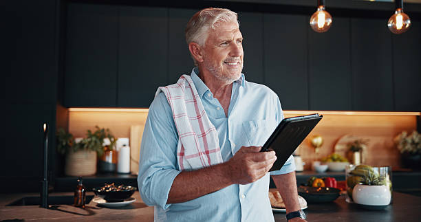 istock Senior man, tablet and meal prep with cooking idea, dinner tutorial or online guide in home. Learning, instructions and mature person in kitchen with decision, diet planning or recipe steps research 2209716960