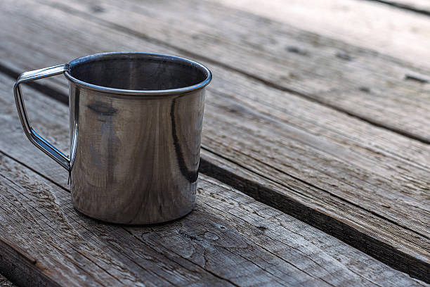 Stainless steel mug on an old wooden table.