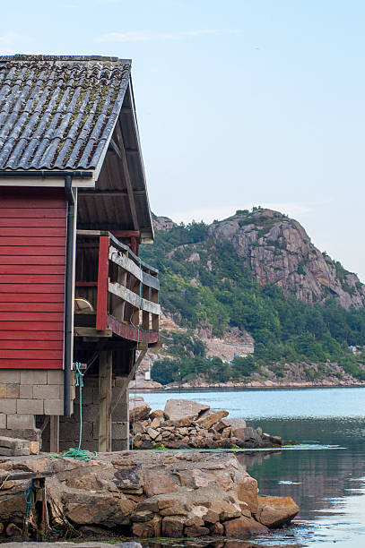 istock coastal cabin by rocky shoreline with mountain view.. 2209720739