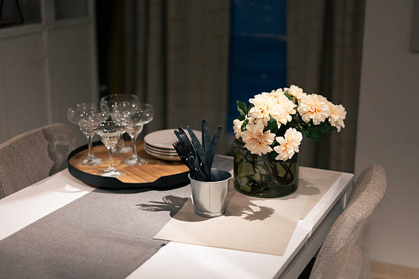 Modern dining table decorated with flowers, cutlery, and glasses, creating a stylish and inviting ambiance for a dinner party