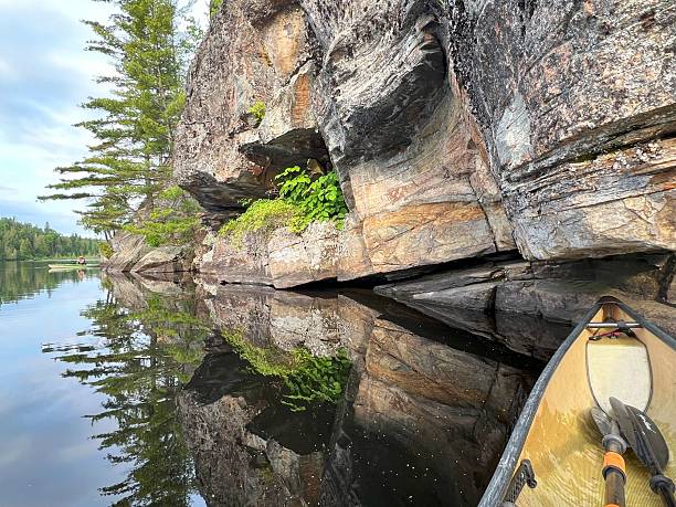 istock Serene Lake View with Canoe and Rocky Shoreline 2209721161