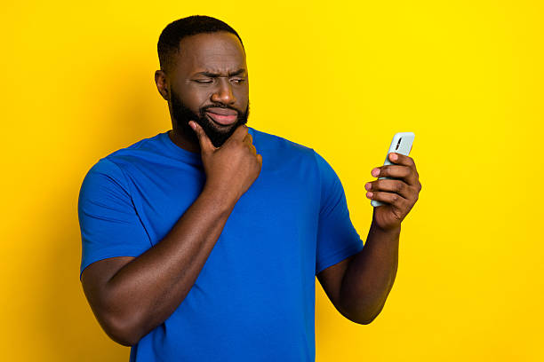 istock Portrait of attractive minded supicious guy using device deciding post smm follow isolated over shine yellow color background 2209721256