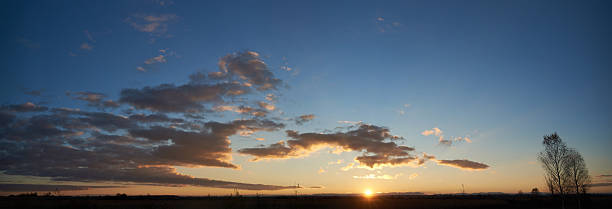 istock Sun sets low on horizon, casting golden glow across landscape. 2209721667