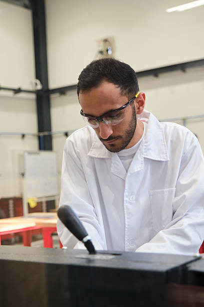 istock Middle eastern man using a woodworking machine wearing safety gloves and lab coat 2209721856