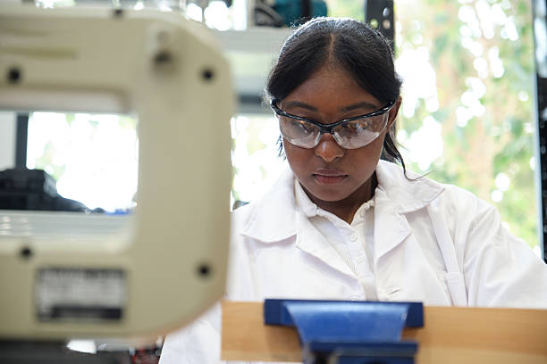 istock Female craftsman working with wood while focusing intently in a workshop 2209723480