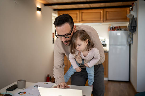 istock Father working from home while holding his baby daughter 2209724632