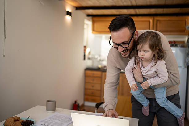 istock Father working from home while holding his baby daughter 2209724810