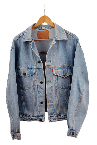 Vintage denim jacket on a hanger against white background