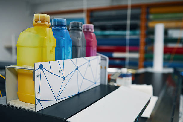 Close-up of colorful bottles for painting paper in workshop