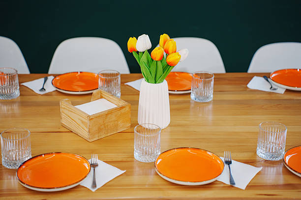 istock Colorful spring table setting with flowers and orange plates ready for dining 2209731920