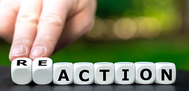 istock Hand turns dice and changes the word action to reaction. 2209738218