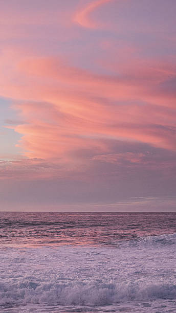 istock Rough sea with pink sunset clouds 2209739515