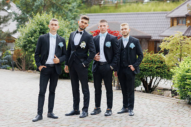 istock Four men in black suits and ties pose for a photo 2209740558