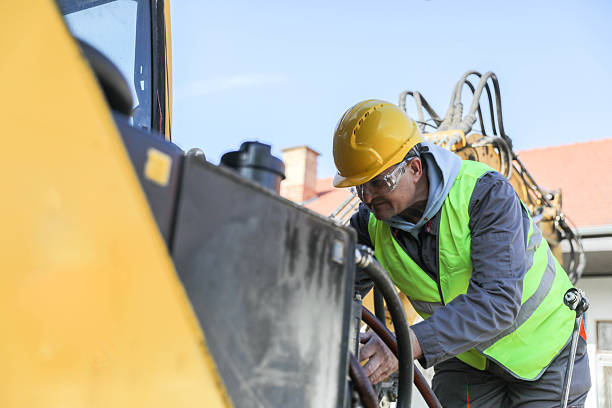 istock Senior man (50+) repairing hydraulic system on construction machinery. Concept: road construction equipment, technician, hydraulic maintenance 2209741873