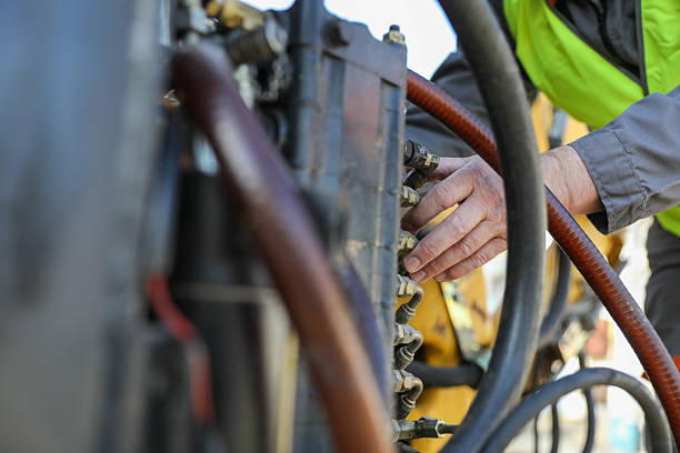 istock Senior man (50+) repairing hydraulic system on construction machinery. Concept: road construction equipment, technician, hydraulic maintenance 2209741879