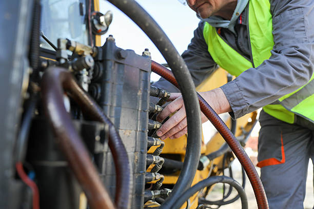 istock Senior man (50+) repairing hydraulic system on construction machinery. Concept: road construction equipment, technician, hydraulic maintenance 2209741886