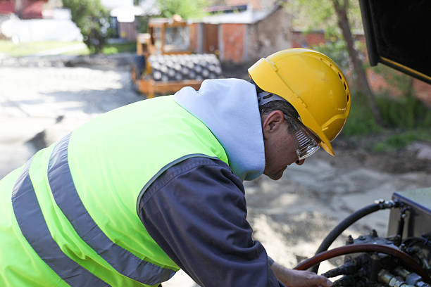 Senior technician repairing hydraulics on construction machinery