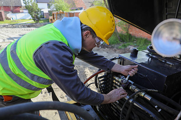 Senior technician repairing hydraulics on construction machinery