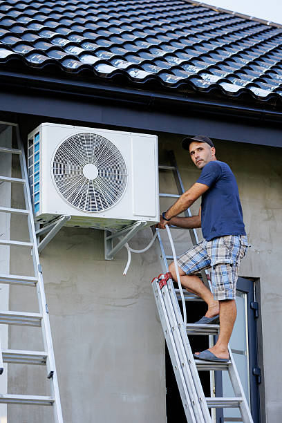 istock A man is on a ladder next to an air conditioner 2209742115