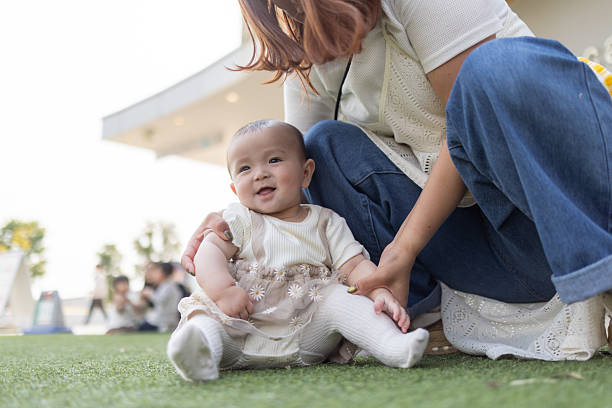 Baby sitting on grass in public park