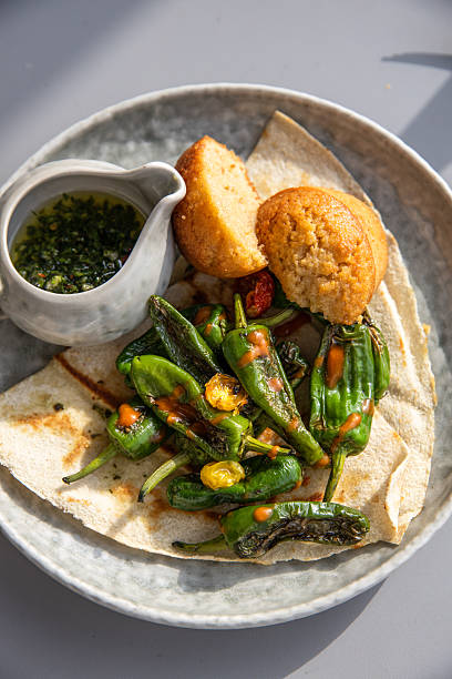 Spanish fried green peppers appetizer tapas dish pimientos de padron served in sunny mediterranean outdoor restaurant