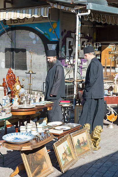 ATHENS, GREECE - OCTOBER 27, 2015: Flea market at Avissinias Square. Two Orthodox priests to bargain hunting