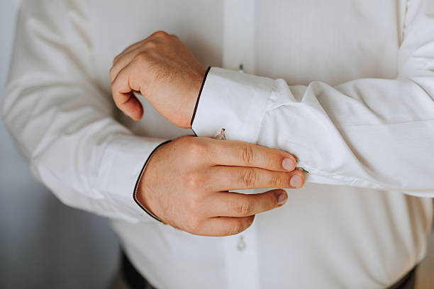 istock A man is getting dressed in a white shirt and black pants 2209751216