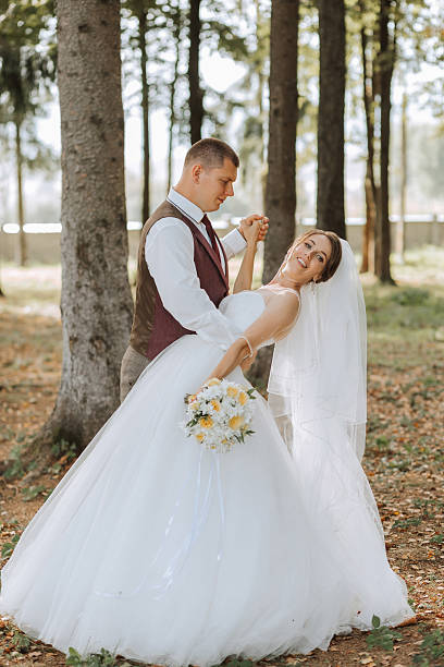 istock A bride and groom are posing for a picture in a forest 2209751711