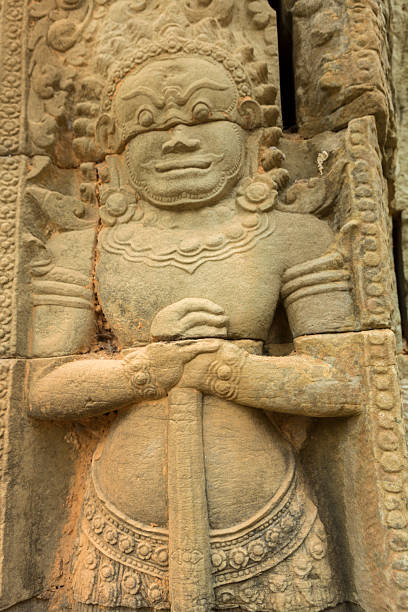A detailed stone relief of a celestial figure greets visitors at Angkor Wat, illustrating the intricate artistry and cultural significance of this historical site.