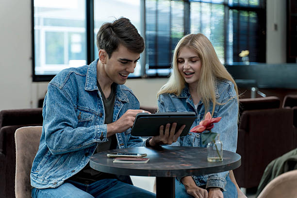 istock Happy young couple using digital tablet together at modern lounge table, sharing content and enjoying quality time in a bright casual indoor setting 2209752234