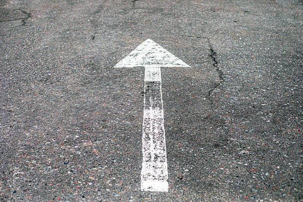 istock white arrow on the road indicating the direction 2209753072