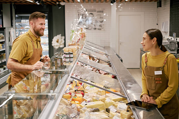 istock Discussing Product Options at Local Cheese Shop Counter 2209754012