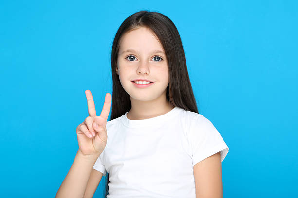 istock Young girl showing gesture by hands on blue background 2209763376