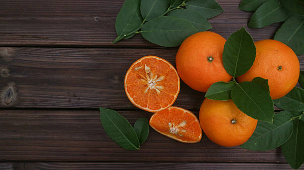 istock Fresh oranges fruit with leaves on wooden background 2209763588