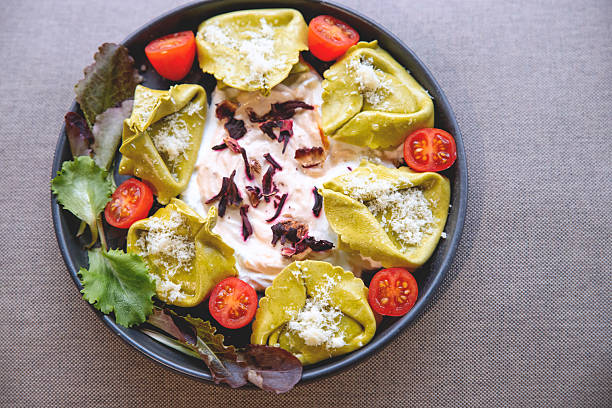 Spinach dumplings on a ricotta sauce with cherry tomato and seasoning. Above top view. Copy space