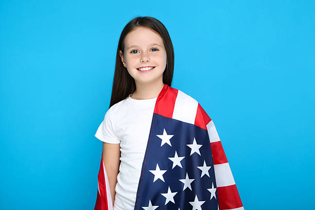 istock Young girl with american flag on blue background 2209763908