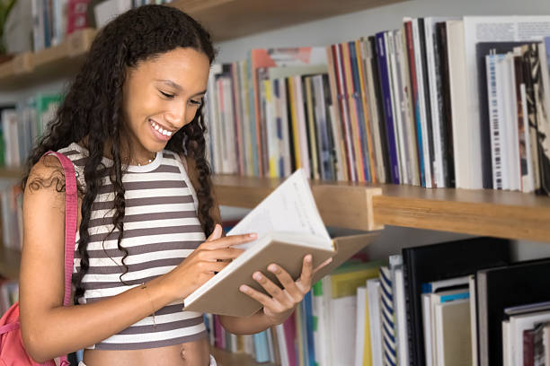 istock Positive young African American student girl reading book 2209764811