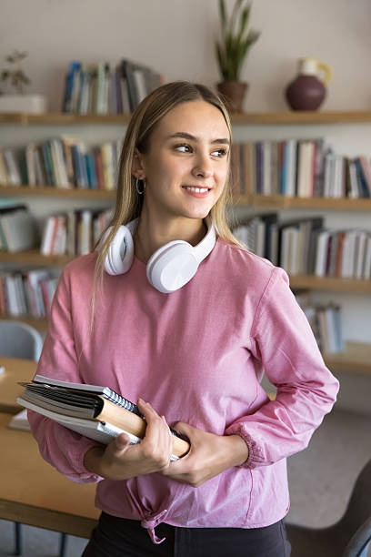 istock Positive young female college student posing in public university library 2209765785