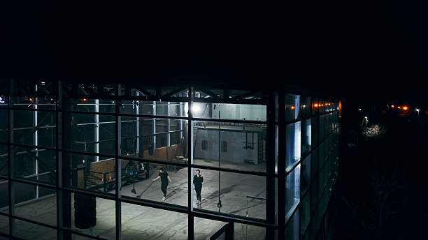 Cleaning staff sweeping the floor of a boxing gym at night
