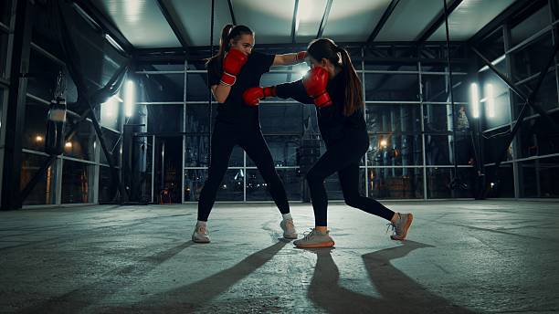 istock Two young female athletes practicing boxing in an industrial gym at night 2209767465