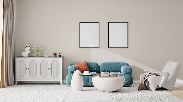 istock Modern living room with minimalist decor, featuring a teal sofa, white coffee tables, and a white sideboard with decorative items. Neutral tones and clean lines create a serene atmosphere. 2209769425