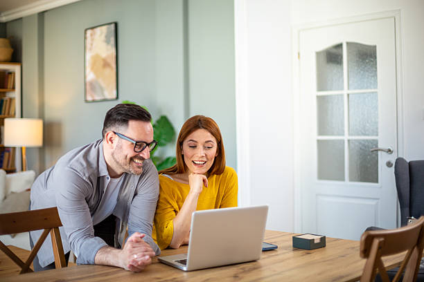 istock Happy couple watching something on laptop at home 2209770043