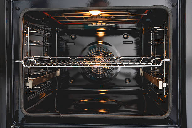 istock Clean and empty modern oven with an interior light and a central rack. 2209770941