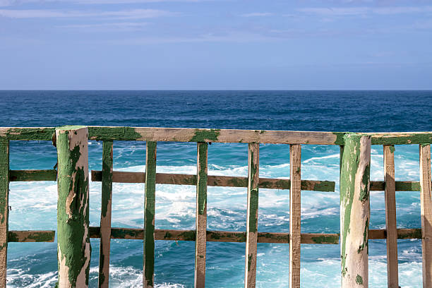 A row of preserved white slave huts lines the turquoise Caribbean coast of Bonaire, a Dutch Caribbean island. Once used to house enslaved laborers working in the salt pans, these structures now serve as historical monuments and cultural heritage landmarks. The image captures both the striking seaside setting and the solemn history embedded in the landscape, offering a visual narrative of resilience and remembrance.