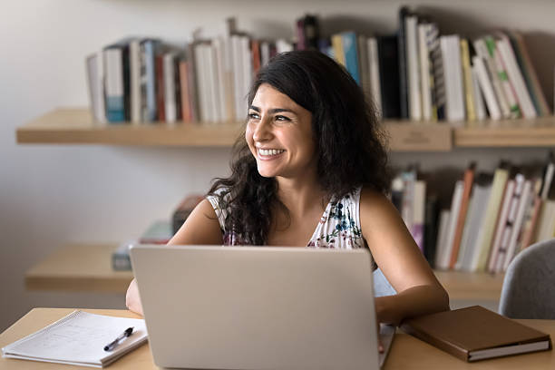 Happy young Indian project manager woman working on business project