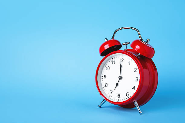 istock Red Retro Alarm Clock on Vibrant Blue Background 2209776195