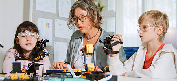 istock White family of mother, daughter, son homeschooling using computer and robotic arm controller. Young kids education at home with parent, technology knowledge learning, children growth concept 2209776867